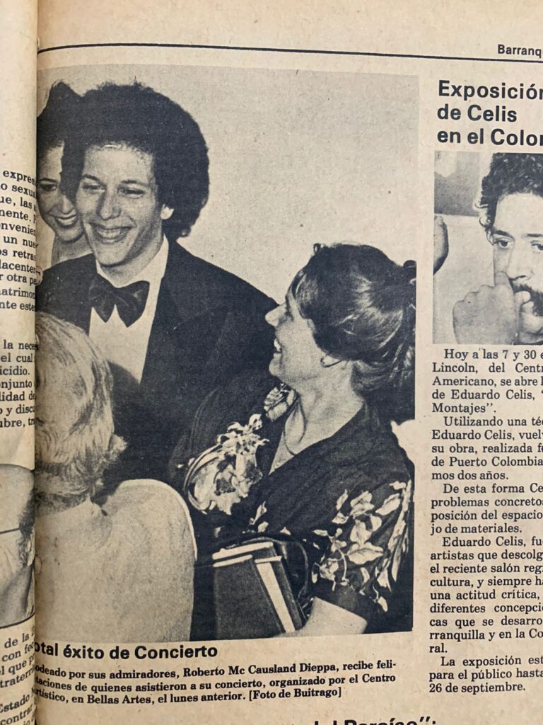 Roberto Mc Causland Dieppa smiles broadly, dressed in a tuxedo, while receiving congratulations from admirers at a concert event.
